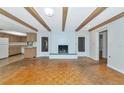 Open living room with hardwood floors, brick fireplace, and wood beam ceilings at 320 25Th W St, Bradenton, FL 34205