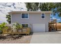 Two-story home features light gray siding, an attached garage and landscaped with palm trees at 3356 Maiden Ln, Sarasota, FL 34231