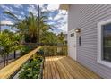 Charming exterior view showcasing a wood deck, siding, exterior lights and tropical landscaping at 3356 Maiden Ln, Sarasota, FL 34231