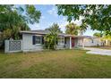 Cozy single-story home with a red door, complemented by well-maintained landscaping, offers a comfortable feel at 3515 W Pearl Ave, Tampa, FL 33611