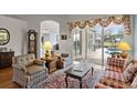 Cozy living room with armchairs, a decorative rug, and a sliding glass door leading to an outdoor pool area at 3859 Little Country Rd, Parrish, FL 34219