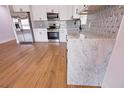 Modern kitchen with stainless steel appliances, white cabinets, light countertops and stylish backsplash at 4501 20Th S Ave, St Petersburg, FL 33711