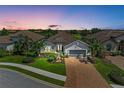 Beautiful single-Gathering home with a well-manicured lawn and a brick driveway at sunset at 4607 Benito Ct, Bradenton, FL 34211