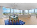 Bright living room with floor-to-ceiling windows and a dining room set, boasting panoramic ocean and golf course views at 545 Sanctuary Dr # B806, Longboat Key, FL 34228