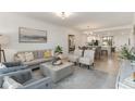 Bright living room with neutral furniture, tiled floors, and an open layout to the kitchen and dining area at 5664 Palmer Cir # 102, Bradenton, FL 34211