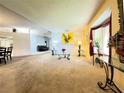 Inviting living room with large window, neutral carpeting, and bright walls at 5711 Garden Lakes Palm, Bradenton, FL 34203