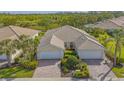 Aerial view showcasing the property's tile roof, brick driveway, lush landscaping, and scenic surroundings at 5934 Guarino Dr, Sarasota, FL 34238