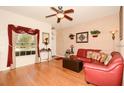 Bright and airy living room boasts hardwood floors, a ceiling fan, and comfortable seating for a welcoming ambiance at 7685 Plantation Cir # B, University Park, FL 34201