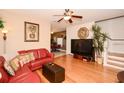 Comfortable living room features hardwood floors, a ceiling fan, and a cozy red leather sofa at 7685 Plantation Cir # B, University Park, FL 34201