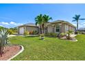 Landscaped front yard with palm trees and shrubs framing this charming home's exterior at 8058 Santa Cruz Dr, Port Charlotte, FL 33981
