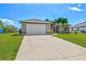 Spacious two-car garage with a long driveway on a sunny day at 8058 Santa Cruz Dr, Port Charlotte, FL 33981