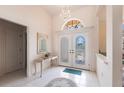 Bright foyer with tile flooring, decorative glass double doors, and a chandelier at 832 Carnoustie Dr, Venice, FL 34293