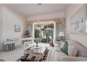 Cozy living room featuring a decorative window treatment, a piano, and sliding glass doors at 832 Carnoustie Dr, Venice, FL 34293