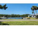 Scenic waterfront view with a private dock, boats, lush greenery, and clear blue sky at 8731 Peggy Ave, Sarasota, FL 34231
