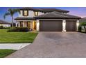 Charming two-story home with a lush green lawn and a three car garage at 11435 Apple Tree Cir, Bradenton, FL 34211