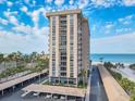 Exterior view of tall condo building with covered parking and beach access at 1212 Benjamin Franklin Dr # 708, Sarasota, FL 34236
