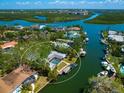 Waterfront property featuring mature landscaping, a pool, dock, and boat lift on a scenic canal at 1248 Northport Dr, Sarasota, FL 34242
