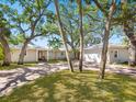 Inviting single-story home with well-manicured lawn and brick driveway, complemented by mature trees at 1248 Northport Dr, Sarasota, FL 34242