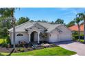 Charming one-story home features a well-manicured lawn, beautiful landscaping, and a three-car garage at 12628 Daisy Pl, Bradenton, FL 34212
