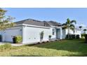 Charming single-story home with a well-manicured lawn, complemented by a fresh blue exterior and a dark roof at 17817 Woodland Ct, Punta Gorda, FL 33982