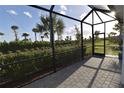 Screened-in patio with brick flooring showcases the beautiful landscaping and sunny skies at 17817 Woodland Ct, Punta Gorda, FL 33982