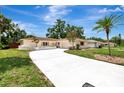 Inviting single-story home featuring a long driveway, shutters, and mature palm trees at 2924 Valley Forge St, Sarasota, FL 34231