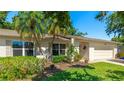 The exterior of the home features lush landscaping, light exterior and a two car garage at 4172 Oakhurst W Cir, Sarasota, FL 34233