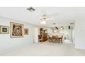 This open floor plan contains an expansive living room with neutral paint and carpet at 4172 Oakhurst W Cir, Sarasota, FL 34233