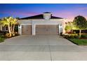 Spacious three-car garage with an expansive driveway and well-lit exterior, perfect for ample parking at 4625 Foxtail Dr, Parrish, FL 34219