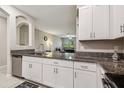 Open kitchen with granite countertops, white cabinetry, and view into the spacious living room at 633 Royal Empress Dr, Ruskin, FL 33570