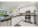 Modern kitchen features white cabinets, granite countertops, and stainless steel appliances at 633 Royal Empress Dr, Ruskin, FL 33570
