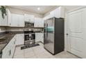 Bright kitchen boasts stainless steel refrigerator, granite counters and modern white cabinets at 633 Royal Empress Dr, Ruskin, FL 33570