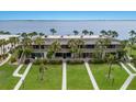 Aerial view of a condo building overlooking the water, featuring well-maintained landscaping and walkway at 6500 Flotilla Dr # 125, Holmes Beach, FL 34217