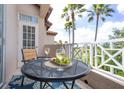 Balcony with a table, wine, and chairs for enjoying the view at 7334 Regina Royale # 74, Sarasota, FL 34238