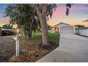Charming single-story home with a well-manicured lawn, mature trees, and a long driveway leading to a two-car garage at 867 Bacon Ave, Sarasota, FL 34232