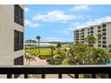 Beautiful view of lush landscaping, palm trees, and waterfront from a private balcony at 8701 Midnight Pass Rd # 206A, Sarasota, FL 34242