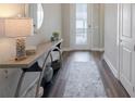 Inviting foyer featuring wood floors, console table, and bright entry door at 8752 Coastal Key Way, Parrish, FL 34219