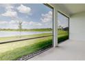 Screened in lanai offering panoramic views of the tranquil lake and lush green surroundings at 8752 Coastal Key Way, Parrish, FL 34219