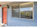Condo's entrance with orange door, exterior light, and window, showing the welcoming features of the home at 10265 Gandy N Blvd # 1004, St Petersburg, FL 33702