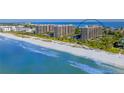 Aerial view of beachfront condo building with private beach access and stunning Gulf views at 1211 Gulf Of Mexico Dr # 704, Longboat Key, FL 34228