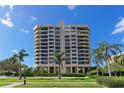 Exterior view of modern high rise condo building with manicured landscaping and palm trees at 1211 Gulf Of Mexico Dr # 704, Longboat Key, FL 34228
