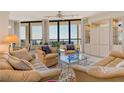 Bright living room with neutral decor, comfortable seating, and stunning ocean views from large windows at 1211 Gulf Of Mexico Dr # 704, Longboat Key, FL 34228