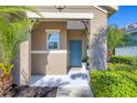 Close up of the front porch of this charming home with a cute blue door and lush landscaping at 12710 Coastal Breeze Way, Bradenton, FL 34211
