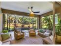 Inviting screened patio with outdoor seating area, ceiling fan, and views of the lush backyard at 12710 Coastal Breeze Way, Bradenton, FL 34211
