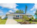 Charming single-story home features solar panels, an attached garage, and a landscaped front yard at 13492 Dibella Ave, Port Charlotte, FL 33981
