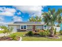 Charming single-story home features a vibrant red door, solar panels, and a beautifully landscaped front yard at 13492 Dibella Ave, Port Charlotte, FL 33981