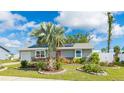 Charming single-story home features a vibrant red door, solar panels, and a beautifully landscaped front yard at 13492 Dibella Ave, Port Charlotte, FL 33981