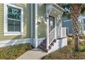 Charming front entrance featuring a cozy porch, detailed trim, and lush landscaping at 319 Compass Point Dr # 201, Bradenton, FL 34209