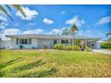 Lovely single-story home with mature trees and a well-maintained lawn under a bright, partly cloudy sky at 3402 Key Ave, Sarasota, FL 34239