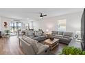Spacious living room with stylish leather seating, ceiling fan, and sliding glass doors to the pool at 3478 74Th Avenue E Cir, Sarasota, FL 34243